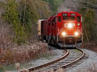 Slowly making it's way west, the engineer on the T07 blows the horn for the crossing ahead.