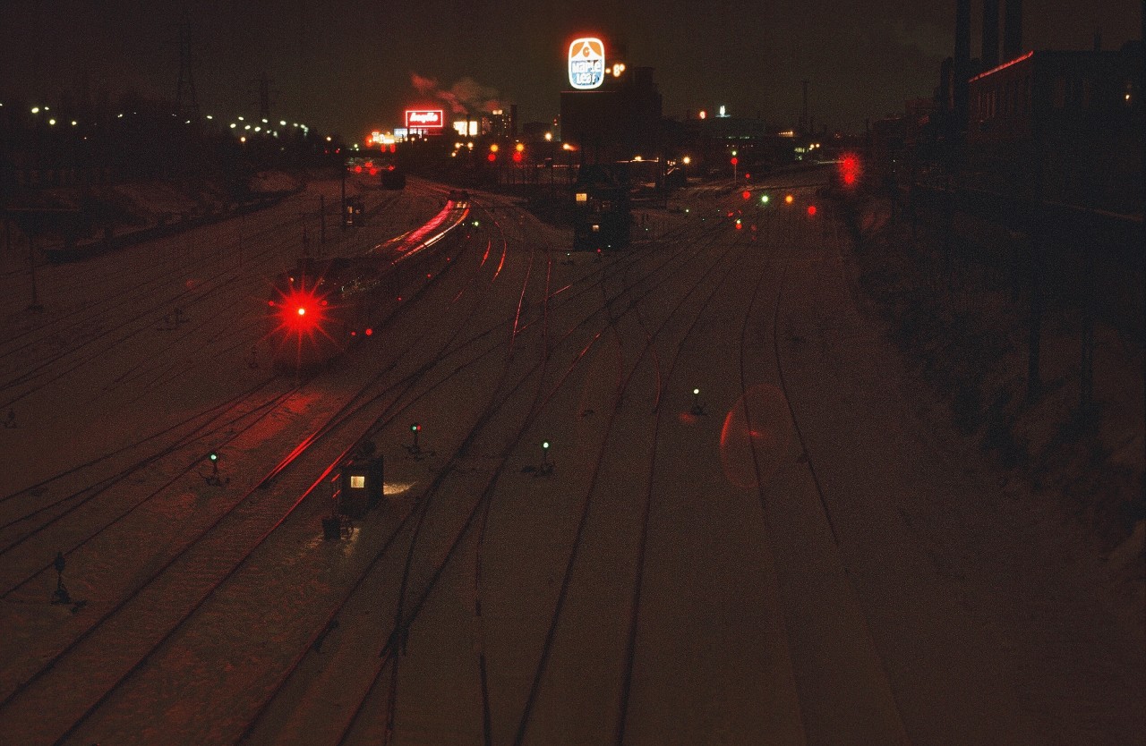 RP contributors have posted some terrific night photography recently – so here is my contribution.


That tail end oscillating mars light is still bouncing around inside my Nikkor AI 35mm f2.8 lens !


( good thing digital did not exist – that mars light would burn a hole in some of today's sensors ! )


Thank goodness for the CN Turbo, to break the monotony of the constant parade of FPA-4's ; FP9-A's ; GO GP-40's and ACPU's (converted FP7-A's etc), not to mention the thousands of SD-40's !


Minus 8 C  - typical winter evening – once the camera equipment acclimatized – no battery required ! -  very slowly and carefully advance the film !


Note the Bathurst Street TTR Switch Tender's shack, likely he has taken refuge in the (operational) TTR Cabin D !


January 2, 1977 Kodachrome, westward at Bathurst Street by S. Danko.


At Bathurst Street:    eastward view