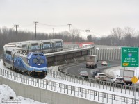 By a cloudy day, AMT #1203 rolls over the highway 640 at Lachenaie QC, on the AMT Mascouche Subdivision. At this place, the train will rolls in the middle of the highway 640.
