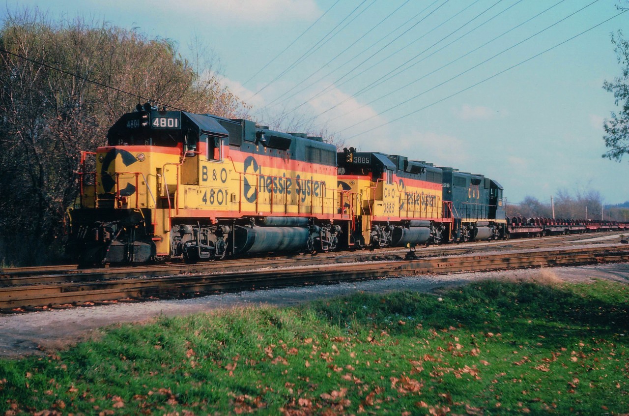 It is the CP/TH&B's turn to run the daily steel train to Nanticoke from Hamilton, a job it shared with CN. The TH&B only had 18 locomotives all told on their roster so extra trains such as this meant bringing in power from CP or leased Chessies to operate them. In this scene, B&O 4801, 3885 and C&O 4828 sit ready by the Stroud Rd crossing at the far west end of Aberdeen Yard.  The train will follow the TH&B Brantford route down to Waterford.