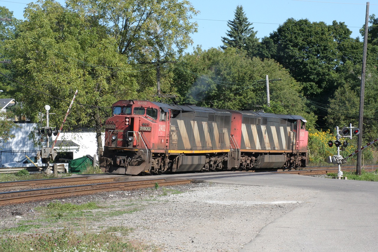 CN 2402 and CN 2420 are the power for a training train back in September 2009. Note that the gates of the level crossing are not all the way down, even though the power is over the road.