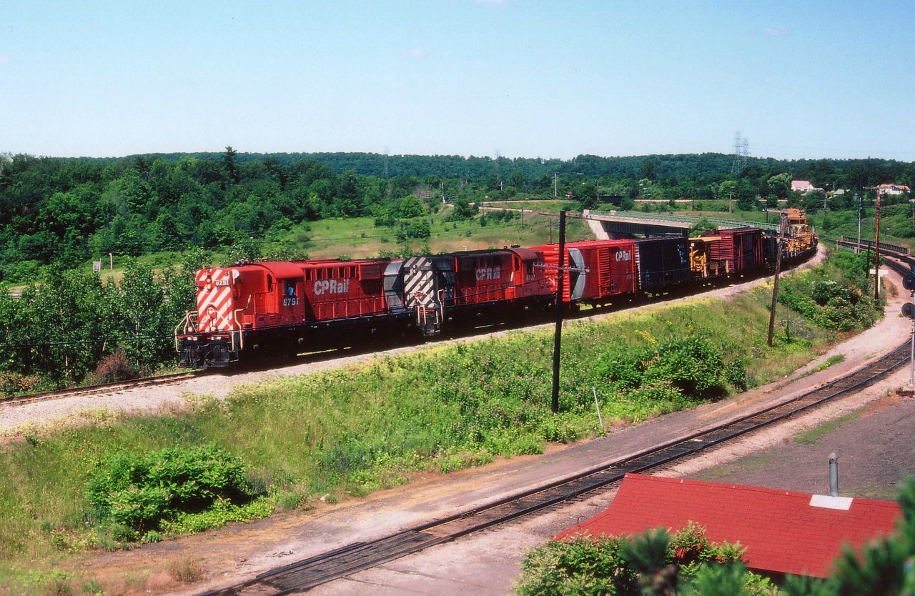 CP 8791 and 8737 with a work train drifting down the grade from Waterdown en route to Aberdeen Yd in West Hamilton. The track in the foreground is known as "CN Cowpath" and the building in the lower corner, at the time MoW storage and now is long gone, was once the site of a Grand Trunk passenger station.