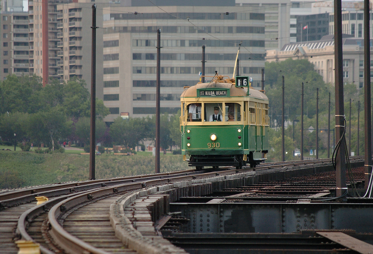 The Edmonton Radial Railway Society's 930, an originally Australian tram built in 1946, comes south on the High Level Bridge on an evening during the Fringe Festival. It might appear there is excess space on the bridge deck to the sides of the track, and originally there were indeed tracks to either side of this central track, which were used by streetcars. CP ran trains along this central track until 1989. The tram in this photo, 930, has now been moved to the society's operations at Fort Edmonton Park.