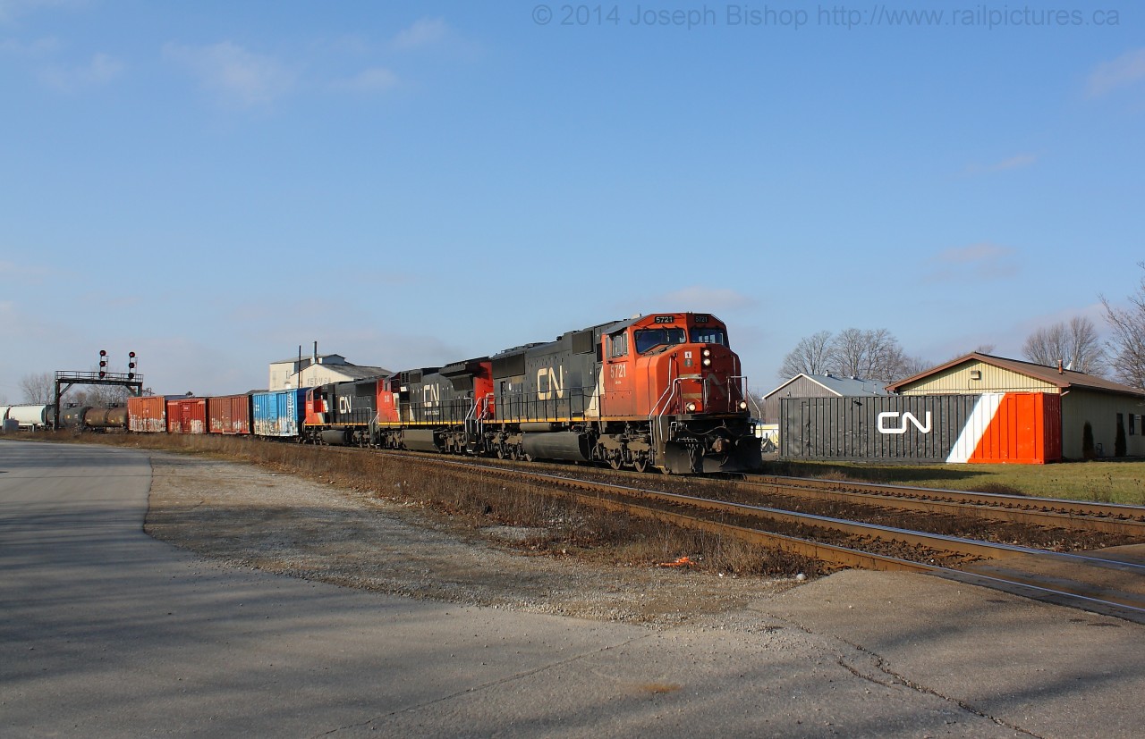 CN 332 roars through Paris behind a trio of CN units.  They are seen passing the recently repainted container at  the Paris yard office, it was painted to be similar to CN's current locomotive paint scheme and looks pretty sharp!