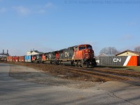CN 332 roars through Paris behind a trio of CN units.  They are seen passing the recently repainted container at  the Paris yard office, it was painted to be similar to CN's current locomotive paint scheme and looks pretty sharp!