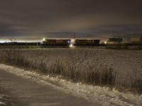 Not exactly a common sight. A high priority CP intermodal freight stopping practically in the middle of nowhere. CP 101 has come to a stop just short of Side Road 25. The reason? I am unsure myself, as my radio is broken. Scanning the tracks for trains as I do sometimes, I noticed an approaching northbound that appeared to be moving rather slow. I decided to head up to Side 30 in hopes of seeing it there. By the time I was there, I noticed the headlights of 101 had still not passed the signal just north of 6th Line. I returned to Side Road 25, and as I was coming up the crossing, the train was stopped just short of it, and the crossing lights  deactivated right as I got there. So an emergency brake application was out of the question. Crew running out of hours, maybe?... Despite being close to Barrie, this seems like a random location to leave a train, on single track, and Baxter siding being less than 5 miles south of here. Whatever the reason, I decided to take advantage of this opportunity by taking a long exposure of 101. Light pollution is from Barrie's south end.