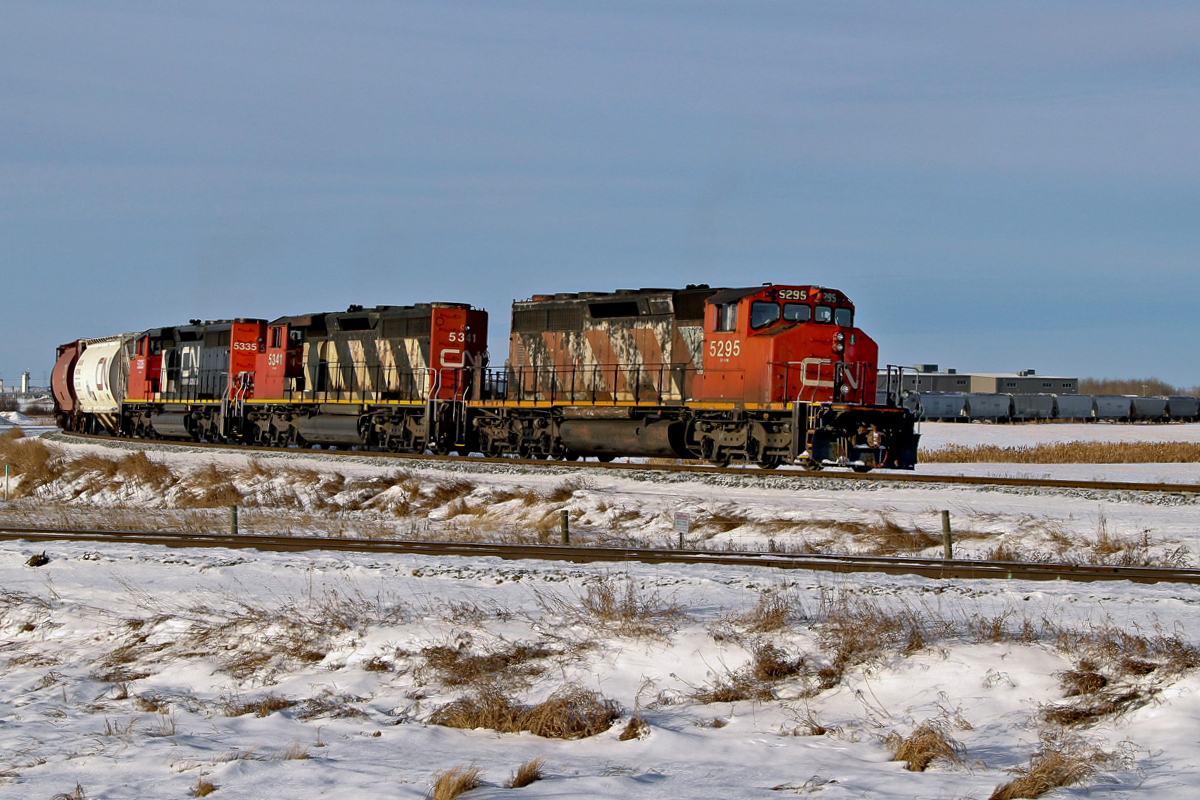 A trio of SD40-2(W)'s, CN 5295, 5341 and 5335 approach Scotford Yard on the CN Vegreville Sub with an eastbound train of grain cars and other hoppers.