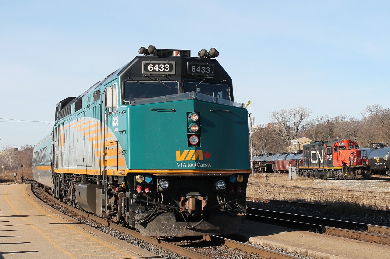 Via 72 arrives at the station stop on a cold Sunday. In the background is the all black yard switcher CN 7000 that had just arrived light engine from the Hagersville sub.