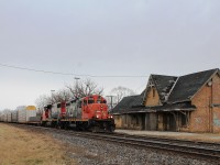 Having arrived light engine with CN 4776 from London to pick up from the siding at Ingersoll, it is seen passing the rapidly decaying old station.