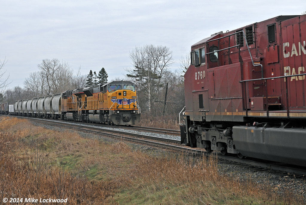 After cooling their heels in the hole for close to two hours, CP 142 finally arrives for a meet with 643 at Spicer. With 124 cars, 643 would not fit into any other siding between here and Toronto other than Oshawa, and the RTC didn't think they'd make Oshawa without delaying 142. With 142 also over siding length, UP 3732 West got to put the newly extended siding here to use. This is the new norm for the Belleville Sub... longer trains and longer delays. 1256hrs.