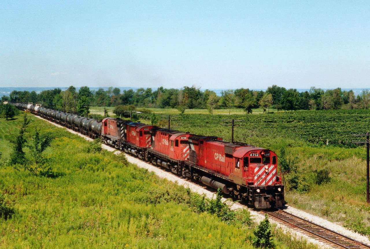Cresting the hill at Vinemount, ON is a top priority Sulphuric Acid train lead by CP 4712, 4238, 4222 and 4218. This train probably originated at Canadian Industries at Copper Cliff, ON., and its' destination could be International Minerals and Chemical Corporation at Port Maitland, or, it might be destined Welland Yard, where it would be handed over to Conrail and taken Stateside. These trains were 'as needed' and I think the end of this particular operation was just before 1990. This photo angle, by the way, is unattainable now due to extensive foliage growth.