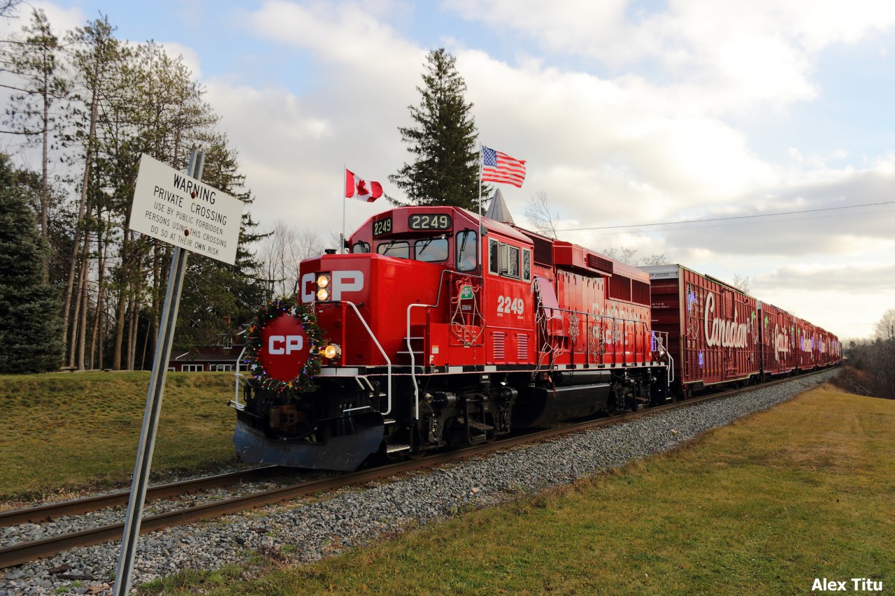 With permission from the owner, my two friends and I set up at a private crossing, awaiting the arrival of the holiday train. Not long after our arrival, we hear horns in the distance and immediatelty recognize it to be the horns of an SD30-ECO. Soon after we hop in the car, and make it to our next location of a 5-location chase with time to spare.