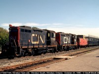 A pair of CN's unique SW1200RSM "Sweeps" has charge of the CN Yard job in Van De Water yard today.  Here the pair, coupled elephant style, have a CN International caboose in tow, along with a long string of empty CN bi-levels as they pull their cut down through the old Electric Yard and in front of Windsor South depot before making a shove back into the yard.