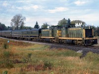 On September 28th 1963, the Upper Canada Railway Society (UCRS) ran an excursion to Lindsay with
Canadian National 4-8-4 steamer 6167, then the train carried on to Haliburton powered by a pair of GMD-1s. Seen here, CN 1915 and 1914 handle the train on a run-by near Kinmount ON, operating on CN's 55.5 mile long Haliburton Sub (Kinmount is listed in the timetable as Mile 33.4).
<br><br>
The GMD-1's were a special Canadian-only model built by General Motors Diesel Division of London ON for the CN starting in the late 50's (with a few built for NAR). Essentially an SW1200RS with a short hood, the 1900 series of 20 units were equipped with B-B Flexicoil trucks and steam generators to be used in commuter and local passenger service out of Toronto's Spadina Roundhouse and other points across the CN system (1900's were commonly used to switch passenger trains at Winnipeg's Union Station).
<br><br>
<i>Note: geotagged location not exact.</i>