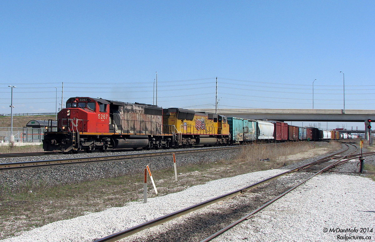 Looking back, I'm not sure what was uglier: an SD40-2W in its decades-old factory paint with peeling black and primer brown showing through, or a relatively newer UP SD70M that, during a visit to LA, probably sat in one place too long. Nevertheless, better than a pair of GE's! CN 5267 and UP 5184 howl through Bramalea GO Station on #399 as it puts in its afternoon appearance, not long after departing MacMillan Yard in Vaughan.