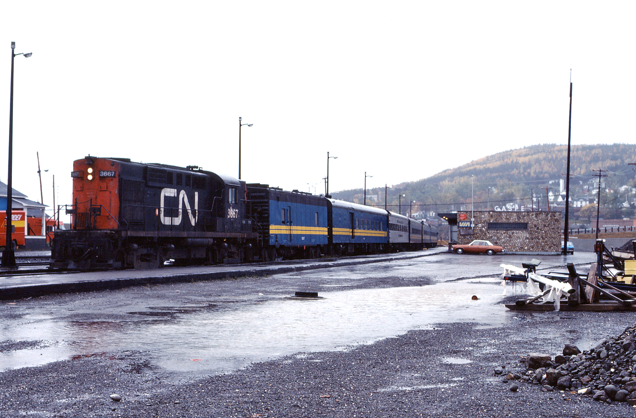 Its a rainy, dreary October day in Gaspe, as train 119 prepares to depart for Montreal.  CN RS18 3667 will guide the train southward through the spectacular scenery of the Gaspe Peninsula.  Unfortunately due to the state of many bridges and deteriorating track conditions along the line, passenger service has been suspended indefinitely.