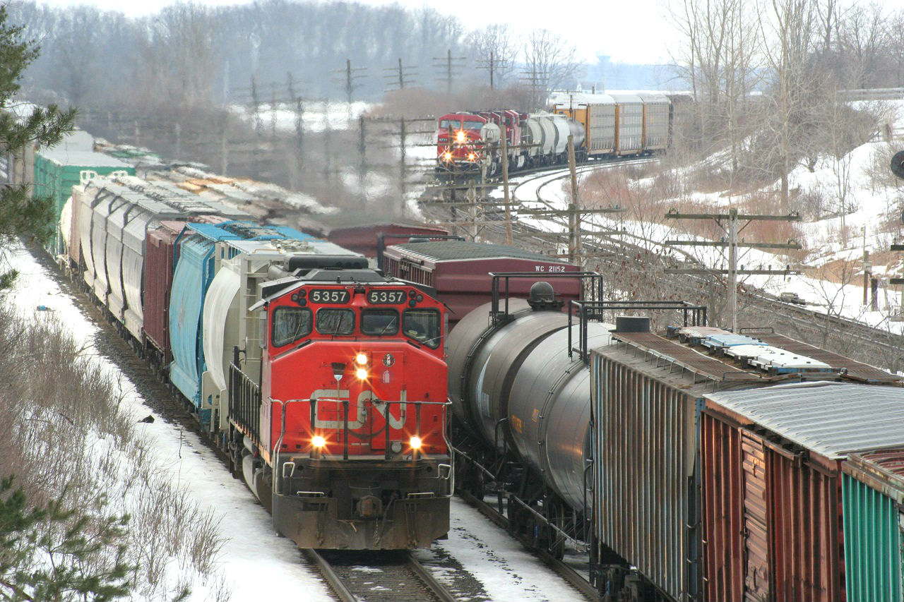 It's a busy moment for trains as all tracks are occupied. From left to right we have CN 534 with CN 5357 leading solo, a CN westbound mixed freight and CP 424 coming in on the CP line.