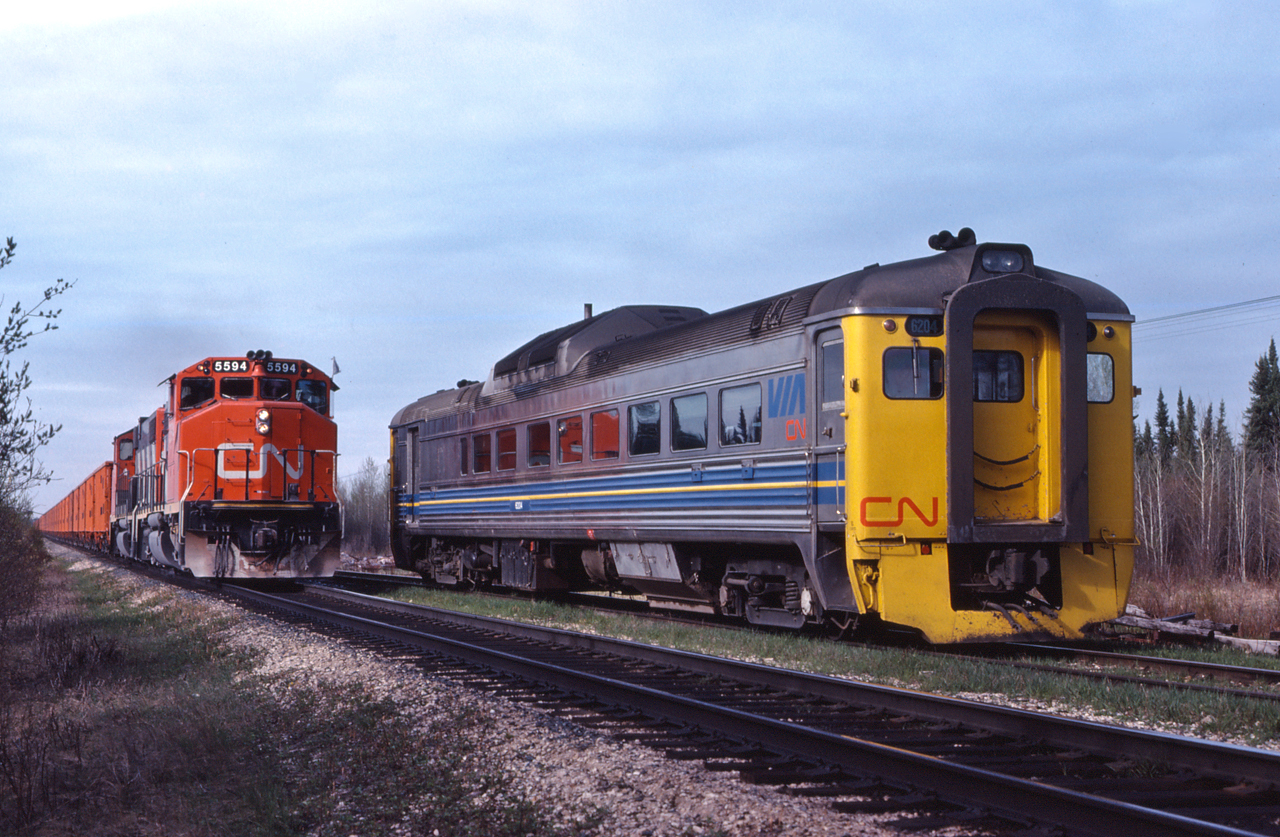 VIA 688 powered by VIA RDC 6204, still in VIA/CN paint awaits the arrival of a south bound ballast extra led by CN 5594 at Turnberry Manitoba.  No. 688 was a Saskatoon to The Pas, Manitoba passenger train seen here on the Turnberry Sub, which runs between Hudson Bay and The Pas.