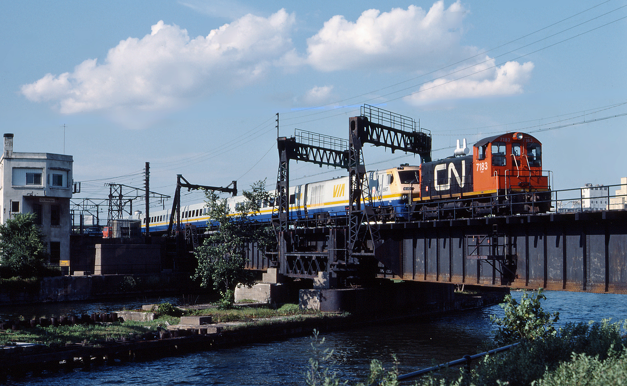CN 7183 shoves VIA 69's equipment over the Lachine Canal and by Wellington Tower, enroute to Central Station.  Once in the station, CN 7183 will cut away and return to the yard while 69 boards passengers for their journey to Toronto.