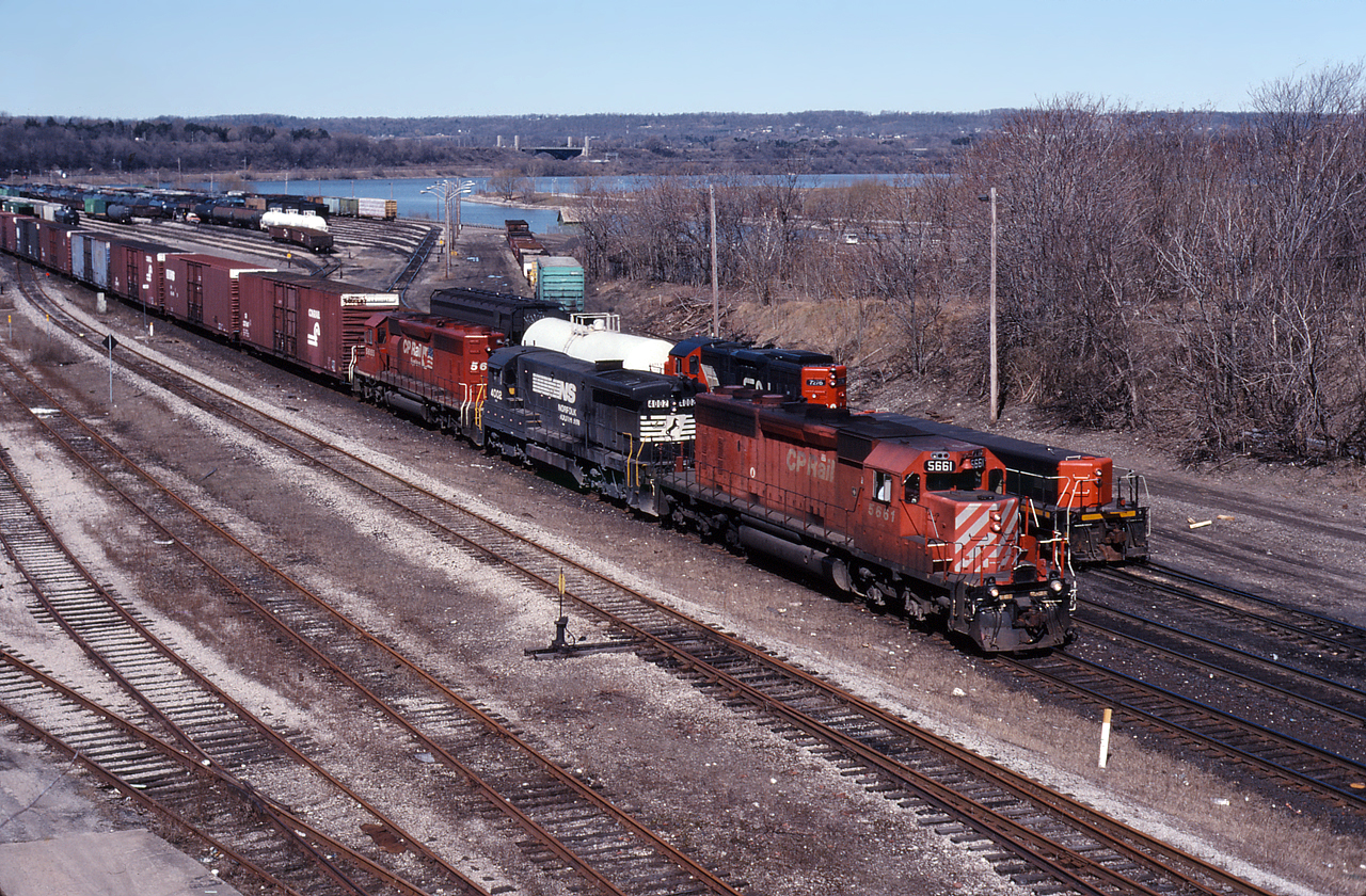 NS 328 eases past Stuart Street Yard as a CN yard job switches out cars on a beautiful April morning.  It was not uncommon to see 328 operating with CP power and today CP 5661, NS 4002 and CP 5655 are in charge of the daily St. Thomas to Buffalo hot shot.