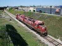 CP 3057 and CP 3038 in the old "dual flag" paint scheme head towards Cambridge as light power in the summer of 2008. They are about to duck under the Wilson Avenue overpass and are paralleling the busy Fairway Road in the south part of Kitchener. Note how faded the paint is on these locomotives - the red has become pink! Contrast this with the vibrant red paint on the new CP GP20C-ECOs that are currently dominating this level of power. 