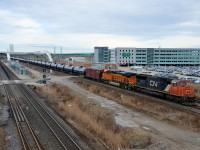 CN 5797 & BNSF 7915 are in charge of CN 711 as it passes the GO parking lot at Pickering. The train (oil empties) is on the Kingston sub but will climb onto the York sub in a few moments. At left is the GO sub.