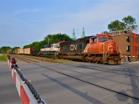 <b>Similar but different.</b> CN 309 crosses De Courcelle street in the St-Henri neighbourhood of Montreal at 6:25 PM with two outwardly identical locomotives (CN 5743 & BNSF 9618) leading and no DPU. CN 5743 is an SD75I built in 1997 and BNSF 9618 is an SD70MAC built for Burlington Northern in 1995. The big internal difference between the two is that the CN unit is DC traction whereas the BNSF unit is AC traction. They make an attractive pair when lashed up together elephant style as they are here.
