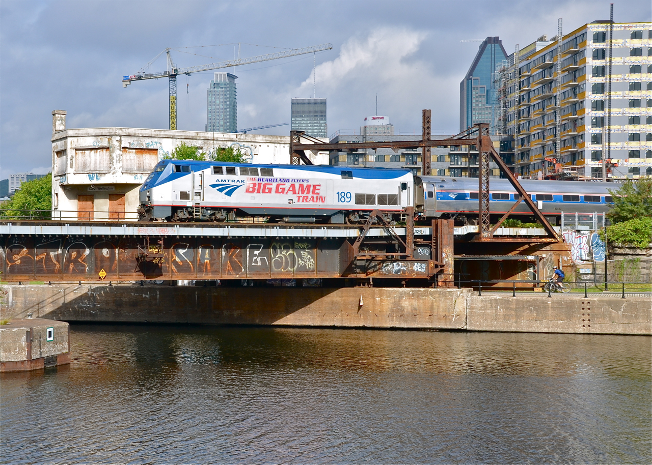 AMTK 189, the 'Big Game' engine is in Montreal for the second time in five days. Here is it 5 minutes out of Central Station as it heads south with the Adirondack, bound for New York City. Most of the morning was cloudy, but the sun came out at just the right time for this shot. It is passing the out of use Wellington Tower.