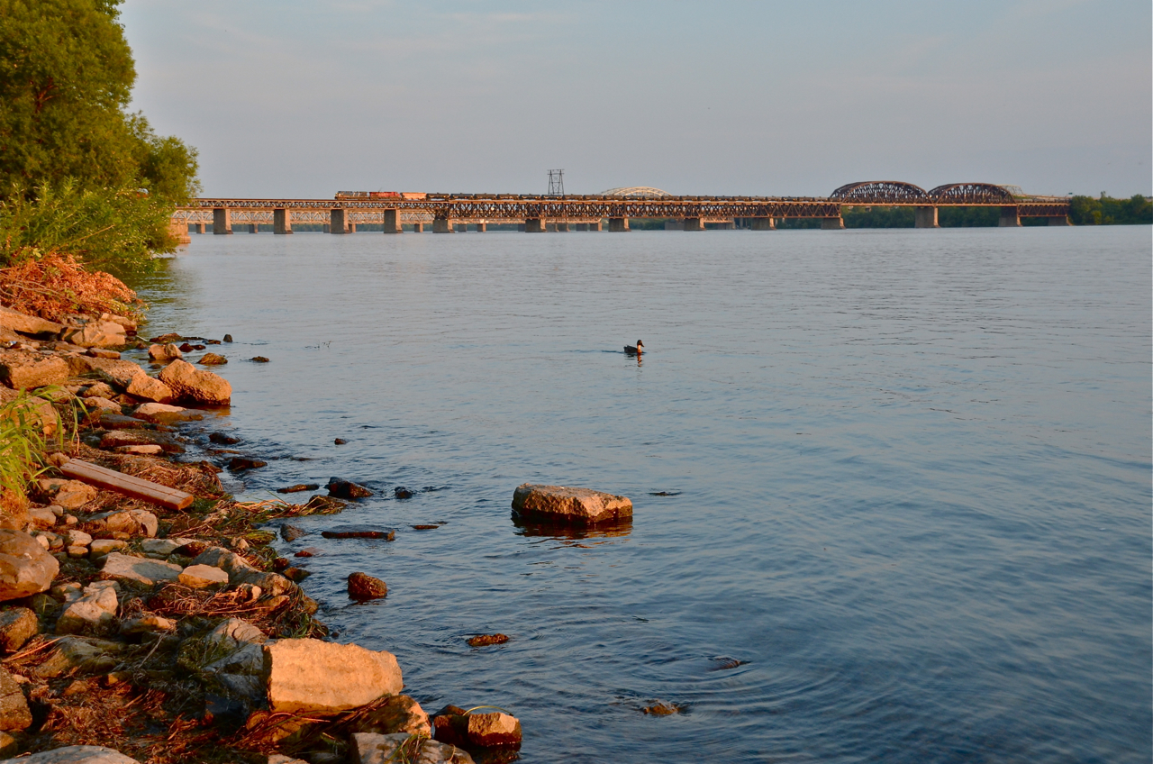Blue and red cross the mighty St-Lawrence. CEFX 1034 and CP 9841 head over the mighty St-Lawrence river, just a few hundred metres away from Lasalle on the island of Montreal and solid land. They are leading CP 609, an empty oil train that originated in Albany, NY.