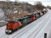 CN X309 is heading west on the freight track of CN's Montreal sub after a crew change at Turcot West with CN 2446 & CN 5485 as power. Fellow railfan and recently qualified CN conductor <a href="http://www.railpictures.ca/author/nicolash">Nicolas Houde</a> waves from the lead engine on this gray afternoon.