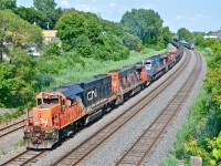 <b>What a lashup.</b> CN 527 heads west through Montreal West with CN 4719, CN 4809, CN 8102 (ex-EMD demo) and CN 2855. These last two units are dead in transit. They were both trailing on CN 708 (new oil train for Valero near Quebec City) but died and were left at Southwark (where 527 originates). This meant that 708 had to take 527's usual power (CN 8933 & 2441), and 527 was back to running with geeps like in the old days. Quite a lashup! The conductor (Lorence Toutant) gives a friendly wave as VIA 57 approaches at right.