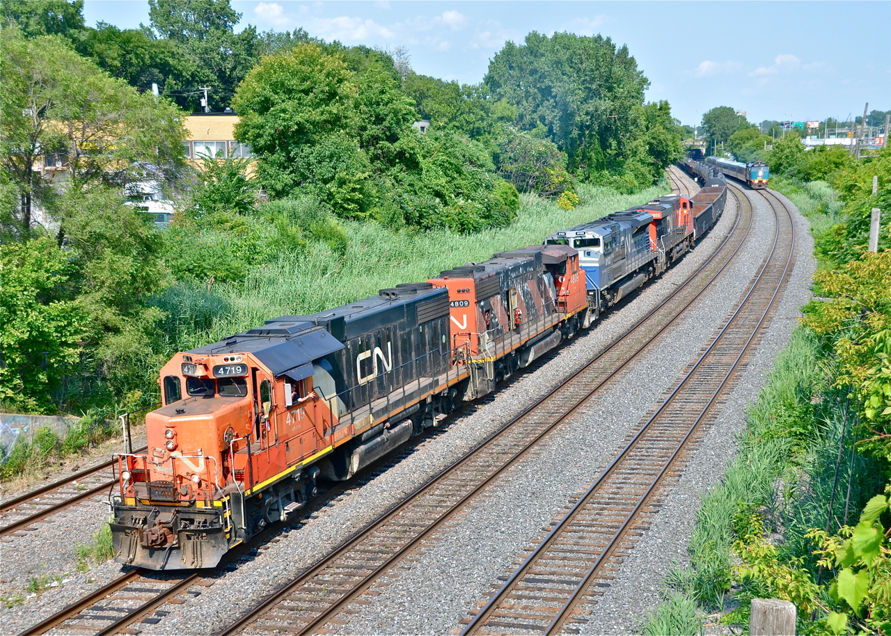 What a lashup. CN 527 heads west through Montreal West with CN 4719, CN 4809, CN 8102 (ex-EMD demo) and CN 2855. These last two units are dead in transit. They were both trailing on CN 708 (new oil train for Valero near Quebec City) but died and were left at Southwark (where 527 originates). This meant that 708 had to take 527's usual power (CN 8933 & 2441), and 527 was back to running with geeps like in the old days. Quite a lashup! The conductor (Lorence Toutant) gives a friendly wave as VIA 57 approaches at right.
