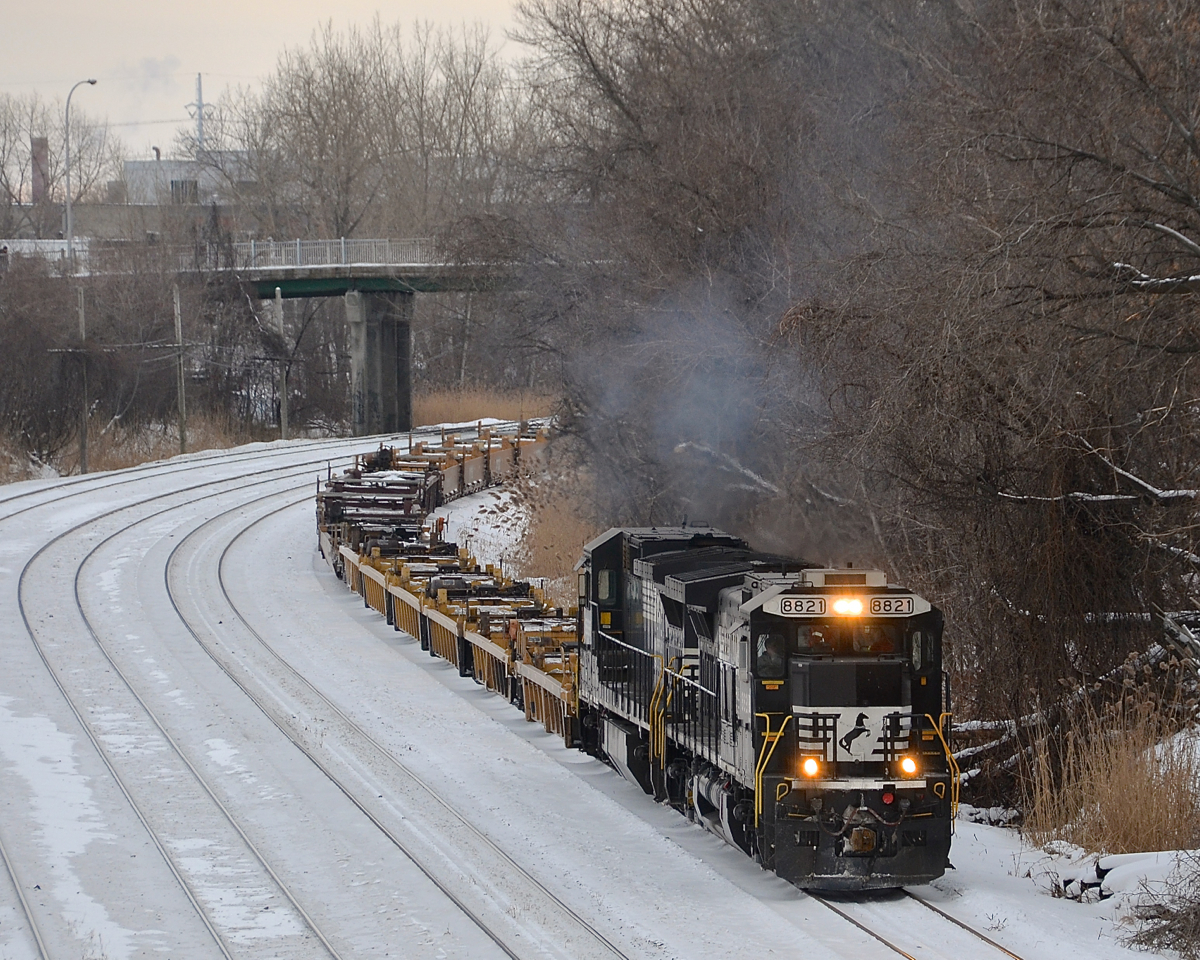 Around the bend. A transfer for the Port of Montreal with empty well cars heads east through Montreal West with a pair of NS standard cab GE's (NS 8821 & NS 8698). This power came in on CN 529. Sometimes CN 'borrows' the NS power durings its daytime layover.