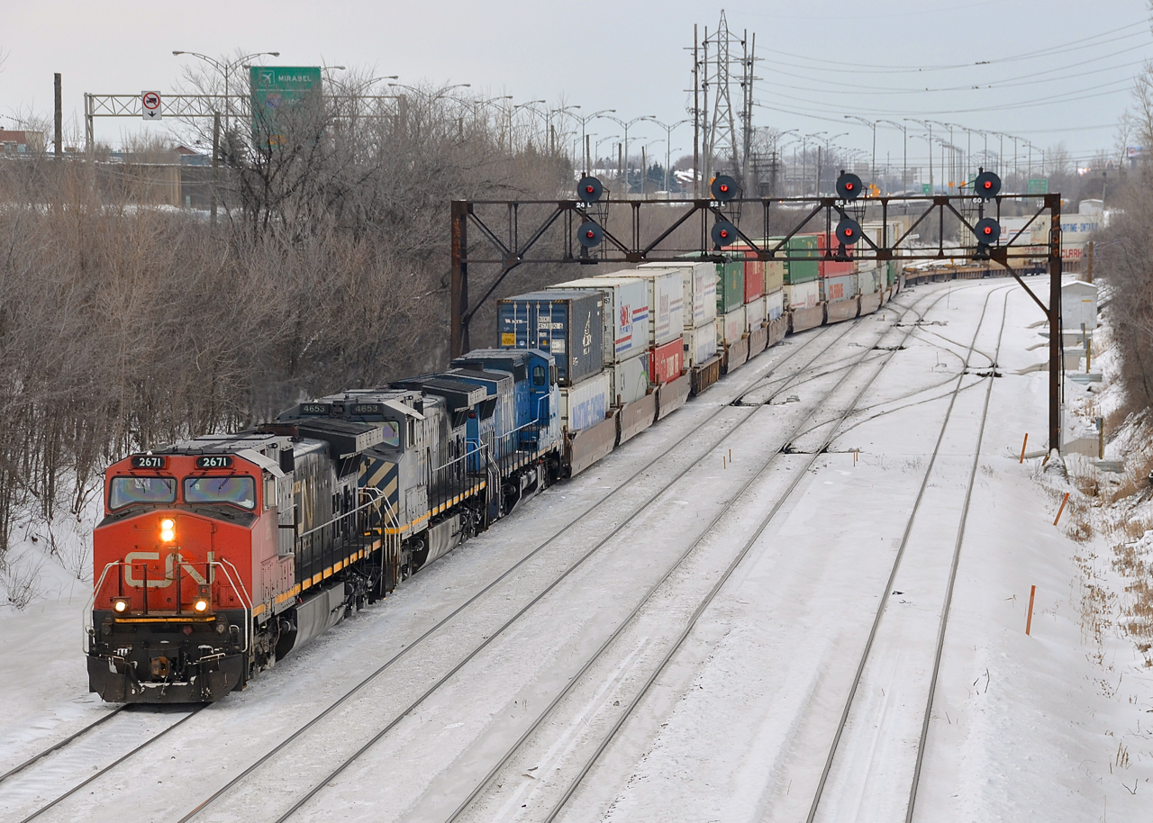 CN 120 with three GE's in three paint schemes (CN 2671, BCOL 4653 & IC 2456) exits Taschereau Yard.