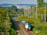 <b>The mountain that gave Montreal its name.</b> With Mount-Royal in the background, VIA 639 (bound for Ottawa) is heading through the Montreal suburb of Pointe-Claire on a beautiful summer evening with VIA 6432 in charge of four LRC cars. 