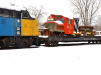 <b>Snow-covered locomotive simulator.</b> The locomotive simulator 'CN 9633' (previously for sale, current status unknown) is back at Exporail, here on a flat car which is coupled to VIA 6309, both snow-covered.