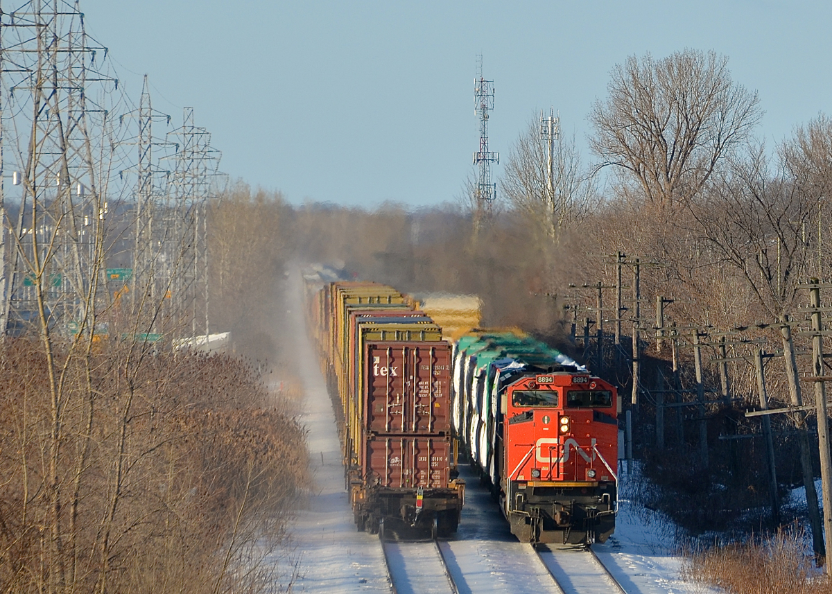 The tail end of CN 149 is passing the head end of CN 310 on CN's Kingston sub in Pointe-Claire. CN 310 has 8894 leading and another SD70M-2 mid-train (CN 8860).