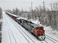 CN 527 heads towards nearby Taschereau Yard with CN 2453 & CN 5445 on a rainy and cold afternoon.