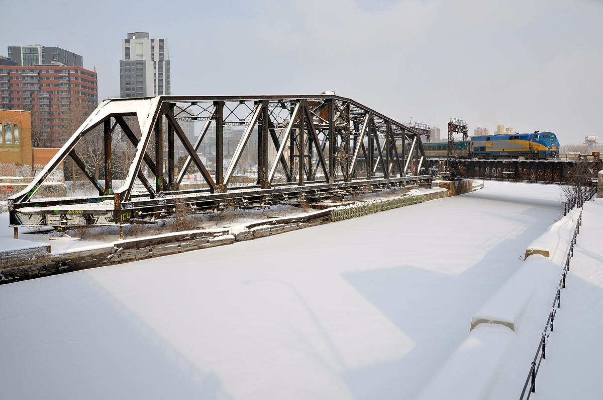 A tale of two bridges. Where the CN St-Hyacinthe sub crosses the Lachine Canal in Montreal (just a bit south of Central Station), there are two bridges. The one at left was a swing bridge that CN freights formerly used to access the Port of Montreal. It has been locked in place and out of use for about two decades. The double-tracked bridge at right (once a lift bridge) is busier than ever, with dozens of movements a day, such as here, with VIA 918 leading VIA 55 towards its eventual destination of Toronto.