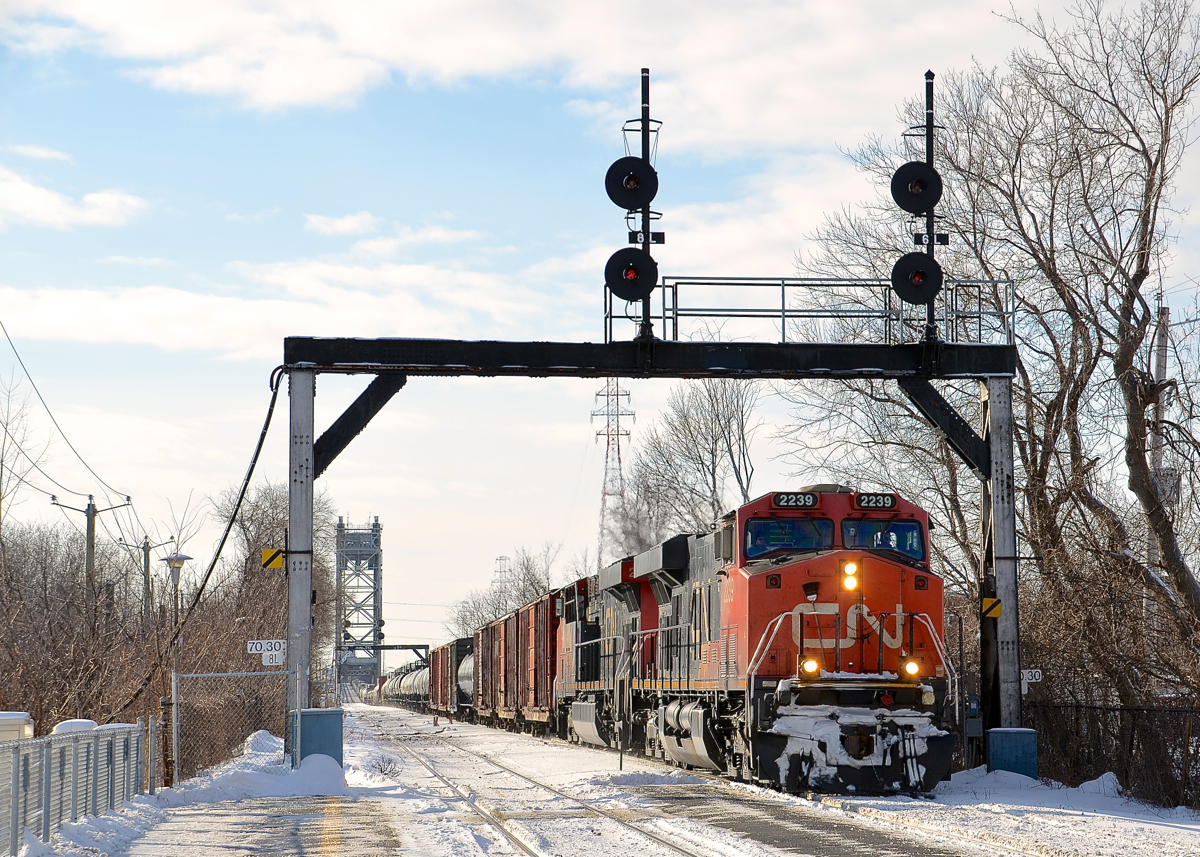 CN 394 with a pair of ES44DC's (CN 2239 & CN 2262) is passing a signal bridge at MP 70.30 of the CN St-Hyacinthe Sub with a fairly long train (about 110 cars). The train is just coming off of the Victoria Bridge, which is in the background. Behind me and out of sight is the St-Lambert station.