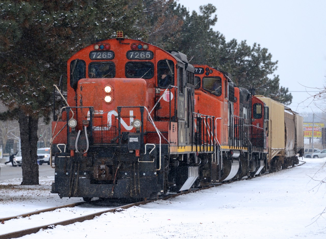 IOX returns from the grain elevator in Sarnia with CN7265, CN4777, CN7039 and three hopper cars. Meanwhile to the left CN Police hand out a ticket to a motorist running the red signals.