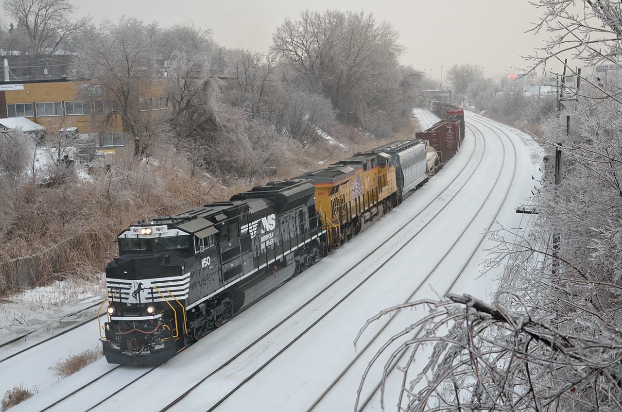 After a day of freezing rain has coated the trees and branches along the right of way CN 529 arrives Montreal with an NS and a UP unit.