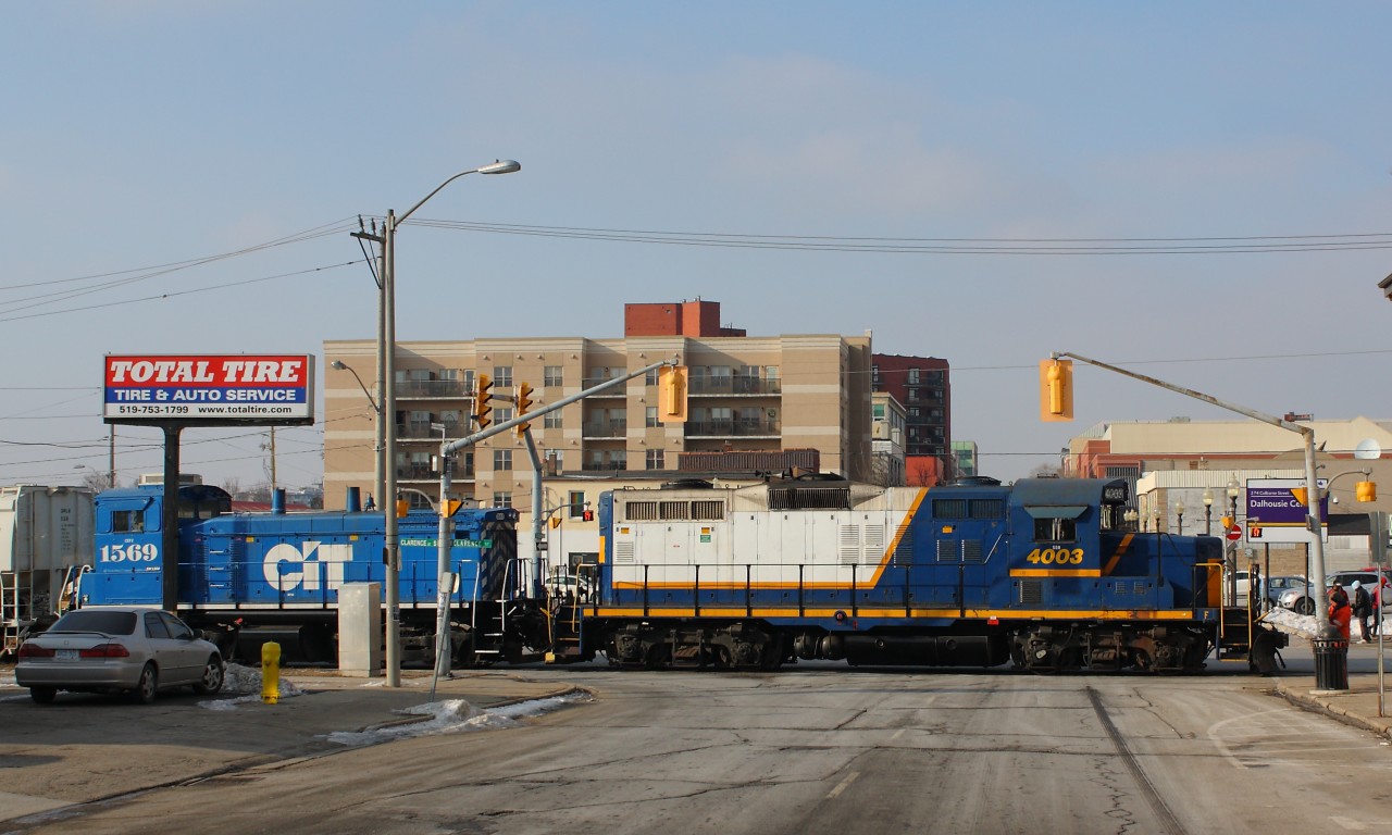 Downtown Disturbance  The horn of RLK 4003 breaks the silence in downtown Brantford as SOR 496 crosses Colborne Street on their return run to Brantford yard after working the Ingenia Polymer Plant at the end of the Burford Spur.  This is the third week of the SOR servicing Ingenia, making the Burford Spur a little more interesting than usual.