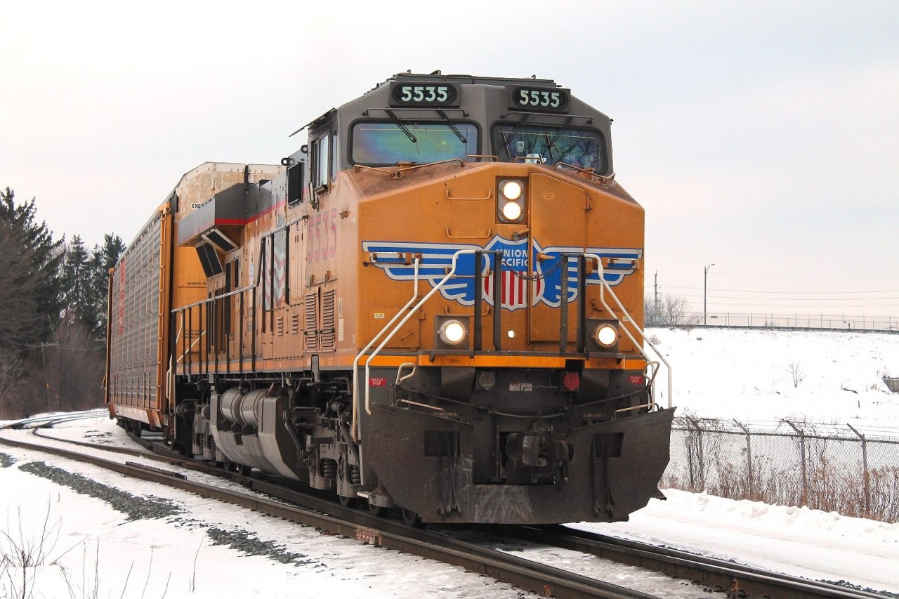 A solo UP loco pulls an autorack train East from the East end of Quebec Street Yard.