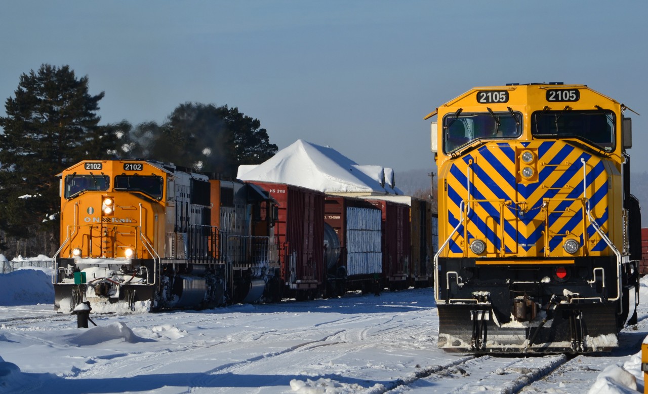with idling 2105 in the foreground, southbound 214 throttles up out of Englehart.