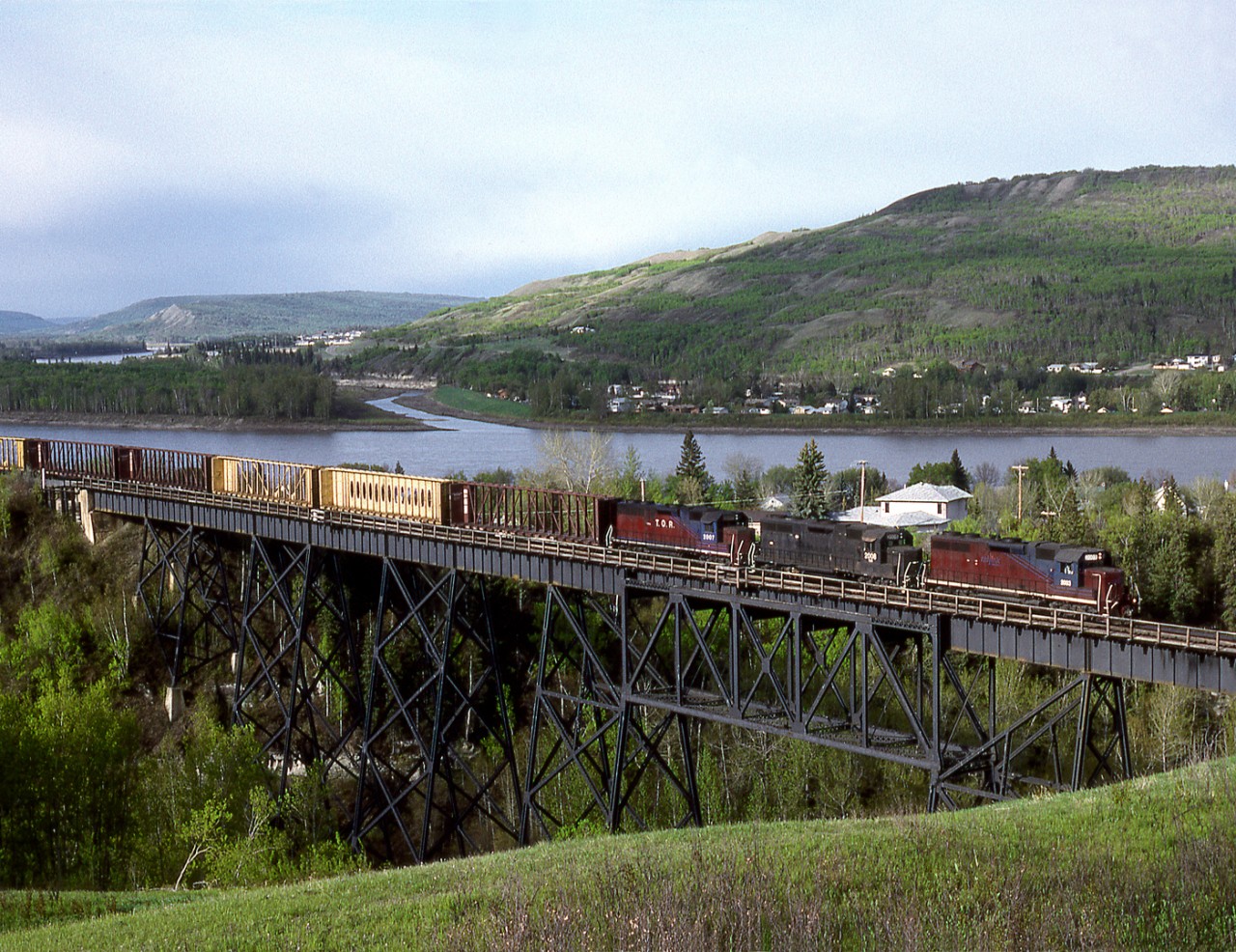 Railinks Mackenzie Northern Railroad train 561 from Edmonton to Hay River NWT crosses Heart Creek as it descends into the Peace River Valley south of the town of Peace River
