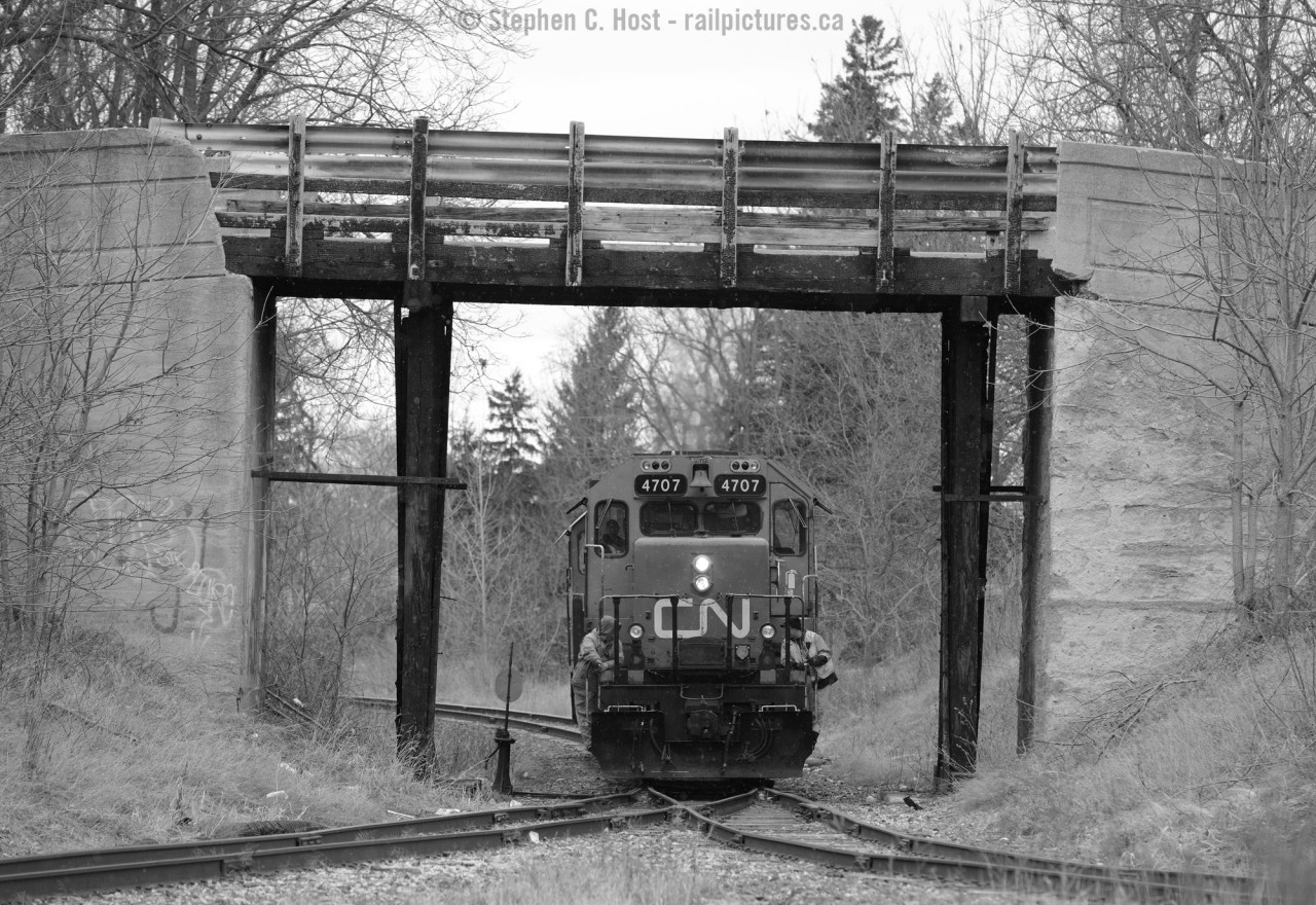 CN 584 rolls under the Barwick St. Bridge during switching of the St. Thomas yard. 
I had thought this bridge should have been replaced by now, but it seems it's also on borrowed time - according to local media - St. Thomas can't figure out what to do with this structure and the development which was to be built, and replace this bridge has been cancelled. This bridge is owned and maintained by CN as of 2014. Notice how black the wooden piers are? How many times has this structure burned?