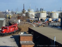 Back in Hamilton - this spur is what remains of the Hamilton Radial Electric Railway right of way - leased by Ontario Hydro jointly to TH&B and CNR in 1947. Since then, heavier rail was laid, the right of way rebuilt to approach the "Steam" railways of the time, TH&B has given way to CPR and CNR is now served by the Southern Ontario Railway. In the background are storage tanks for Rutgers VFT Terminals. The train pictured is CP's night Kinnear yard job, nearly done or the day and returning back to the yard. The four cars in tow are from A&M Metals by Parkdale Ave and a tank from VFT. <br><br>The time is 1100 exactly - this and the next two posts from me are a series I'll title - '36 minutes in Hamilton'.