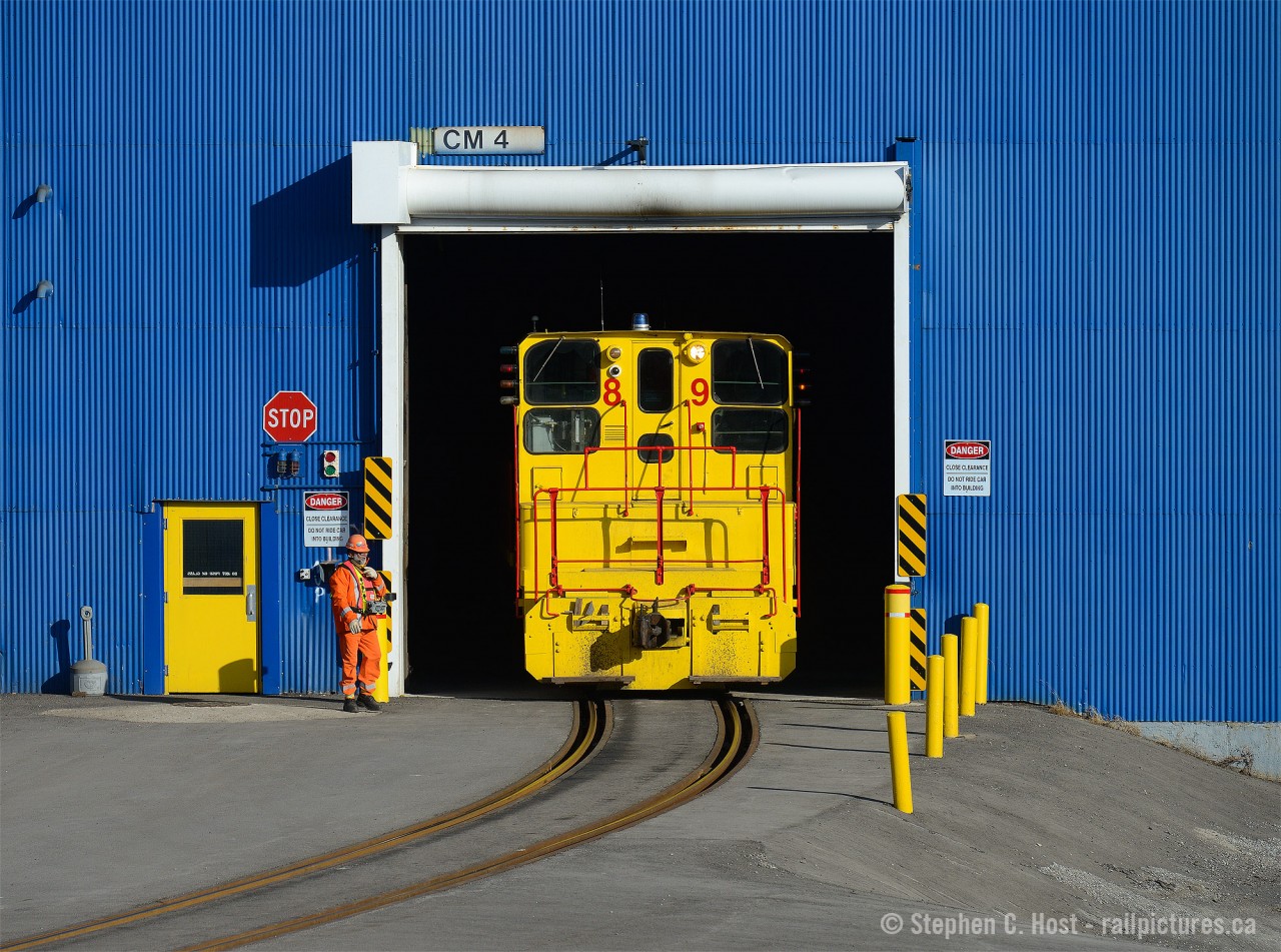 The time is 11:10 - 10 minutes earlier I was photographing CP near Strathearne (click here for photo) when I heard sirens - sounded like the warning siren that goes off - as was the case as I took this photo - when the Transportation Department is in the plant with railway equipment. I was right and the wind was carrying sound just the right way. I made my way west down Burlington St just in time to catch the action.
In this scene, the Beltpack operator at the yellow door has just switched #89 to reverse, the headlight turned on and the crew is about to remove 6 loaded coil cars from the "z" Galvanizing line and place them in the outbound yard. Note: SW900 #89 was delivered new to Stelco in 1964 and has been here ever since. No ditch lights, plenty of modifications otherwise (Antennae, a fisheye camera just above the number 8, and a blue strobe light which seemed inoperative)
A Brakeman will ride the tail end of the movement into the yard - hence a two man crew. After, I realized I had one more shot to go for.. CP was returning to Kinnear after my shot at 11:00. Part 2 of "36 minutes in Hamilton."