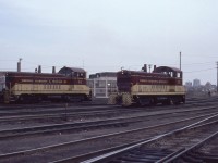 T, H & B switchers No. 51 (NW-2; EMD January 1948) and No. 55 (SW-9; GMD December 1950) are shown performing their workaday duties at the Aberdeen Yard. Both are pioneering units; No. 51 the first T, H & B end cab switcher, No. 55 the first GMD built model on the roster. No. 51 was conveyed to Ontario Southland Railway in 1992 and is still resident in Salford, Ontario – see http://www.railpictures.ca/?attachment_id=10014. Following full acquisition of T, H & B by parent Canadian Pacific, No. 55 would depart the roster in 1988 and subsequently find work as an industrial switcher for a number of new owners – see http://www.thbrailway.ca. Note the detail differences between the two switcher models. Note also in the background on the right the massive concrete coal tower located at the Chatham Street locomotive service facility.